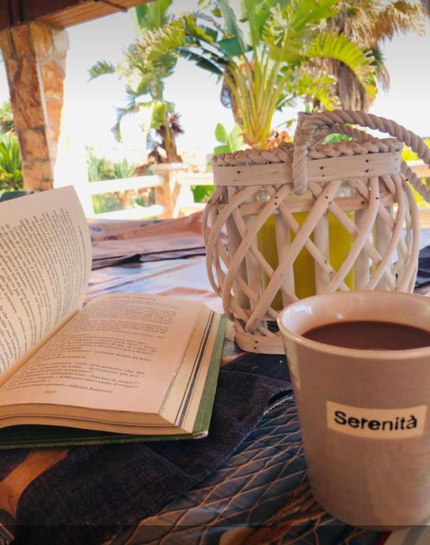 a book and a cup of coffee on a table at Ville Alba & Azzurra in Polignano a Mare
