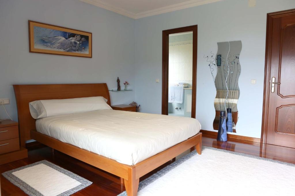 Schlafzimmer mit einem Bett, einer Kommode und einem Spiegel in der Unterkunft Casamary Planta Alta in Pontevedra