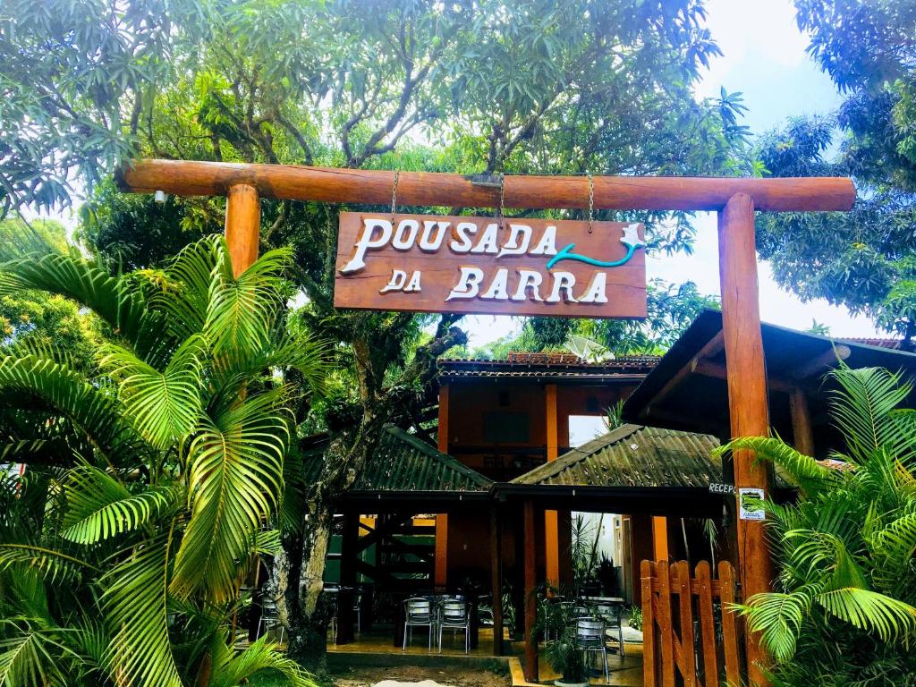 een bord voor een restaurant in baraka met stoelen en bomen bij Pousada da Barra in Barra Grande