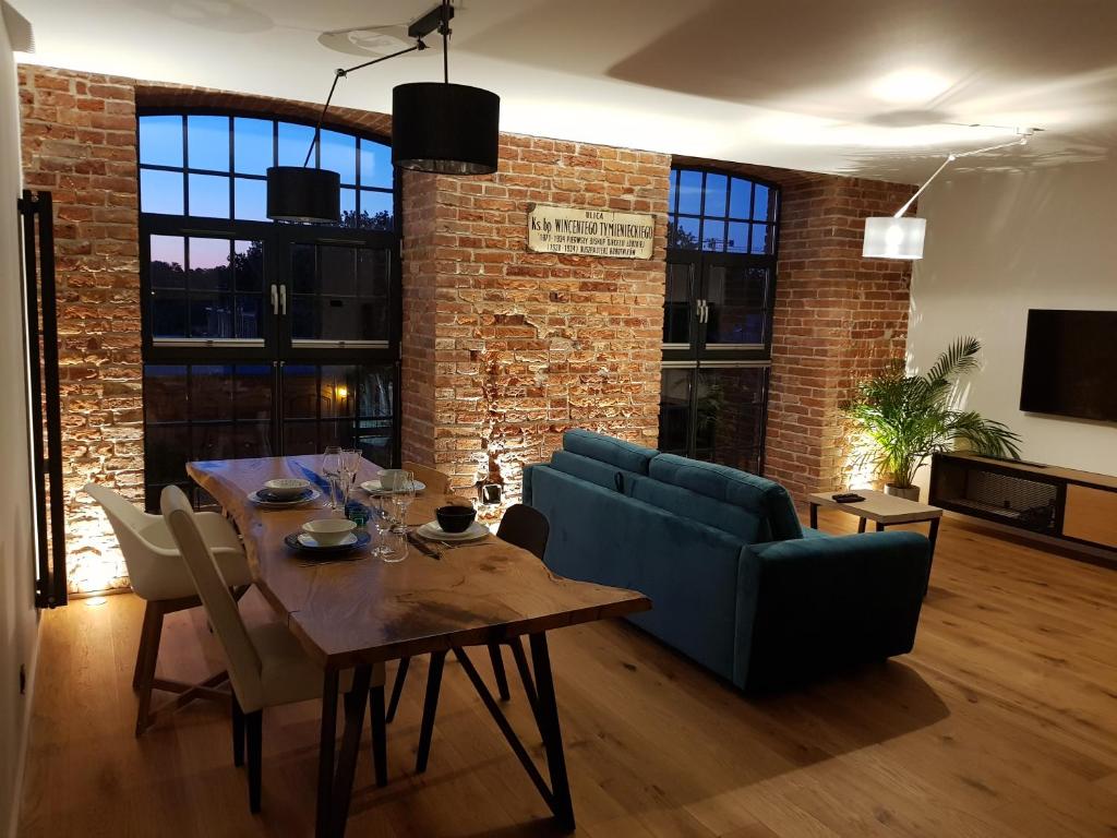 a living room with a table and a brick wall at Home Factory in Łódź