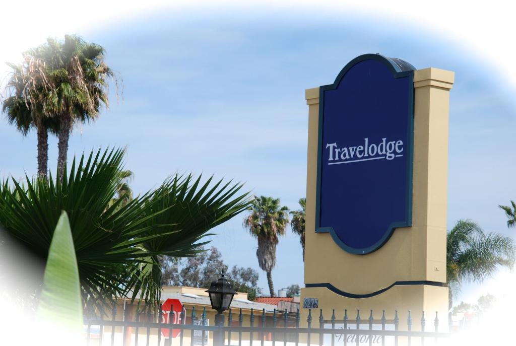 un cartello per lo zoo di taronga con palme sullo sfondo di Travelodge by Wyndham San Diego SeaWorld a San Diego