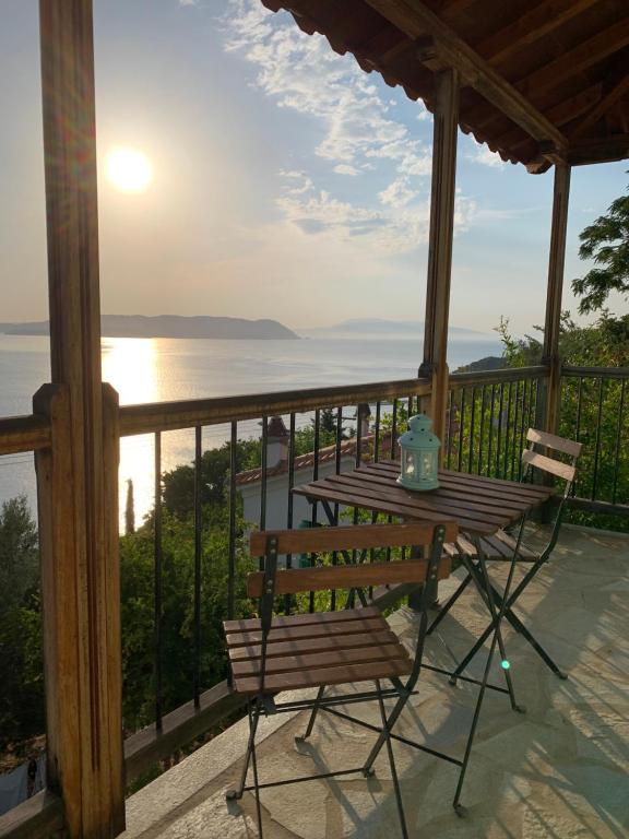 a table and chair on a balcony with the ocean at Bouzouki panoramic sea-view in Klíma