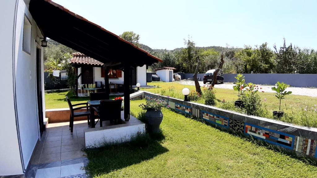 a house with a patio with a table in a yard at House Anna Houhlia in Vourvourou