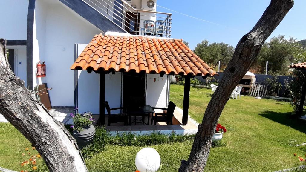 a small white house with an orange roof at House Anna Houhlia in Vourvourou