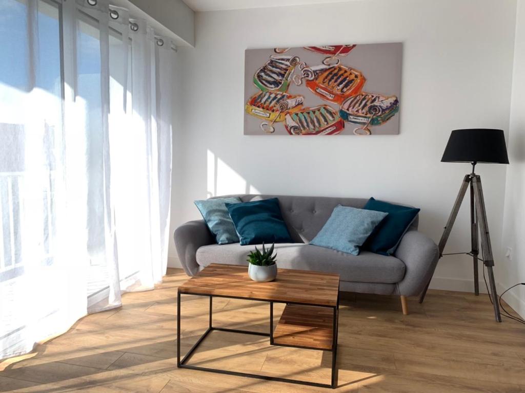 ein Wohnzimmer mit einem Sofa und einem Tisch in der Unterkunft Appartement vue mer in La Baule