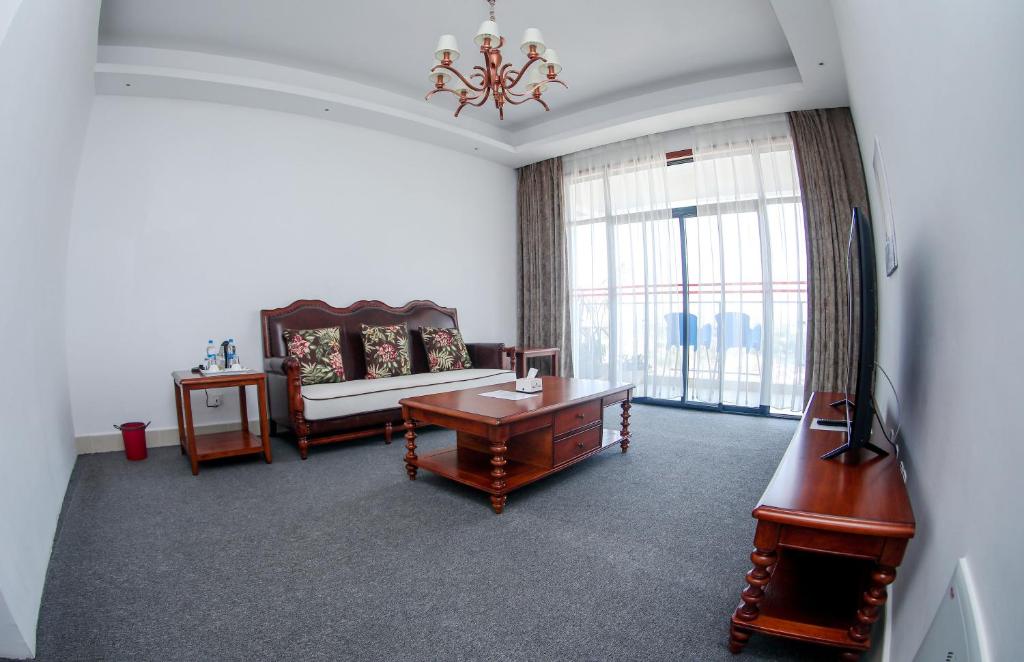 a living room with a couch and a table at Lark Hotel in Dar es Salaam