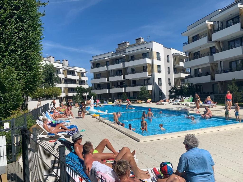 a group of people laying around a swimming pool at Apartament Emilia Ustronie Morskie in Ustronie Morskie