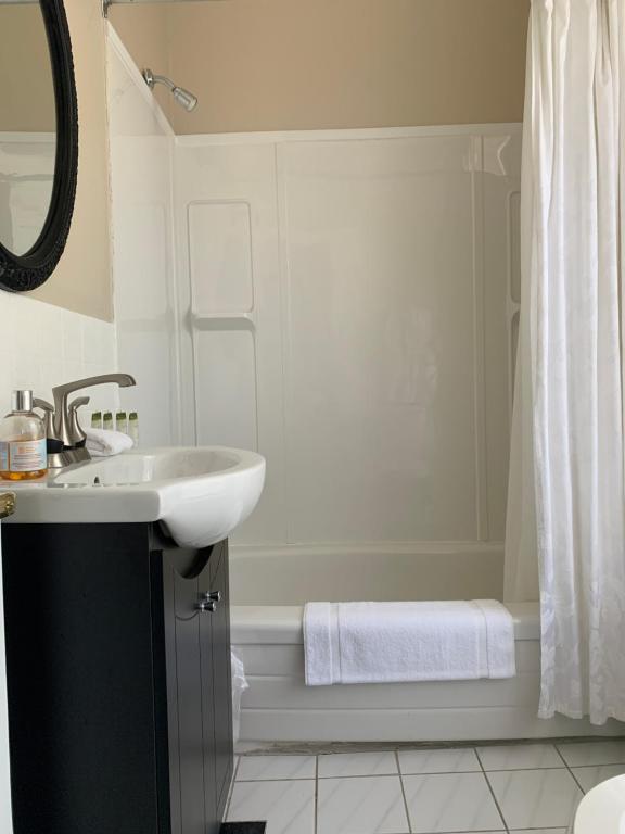 a white bathroom with a sink and a shower at Inn at the Falls in Bracebridge