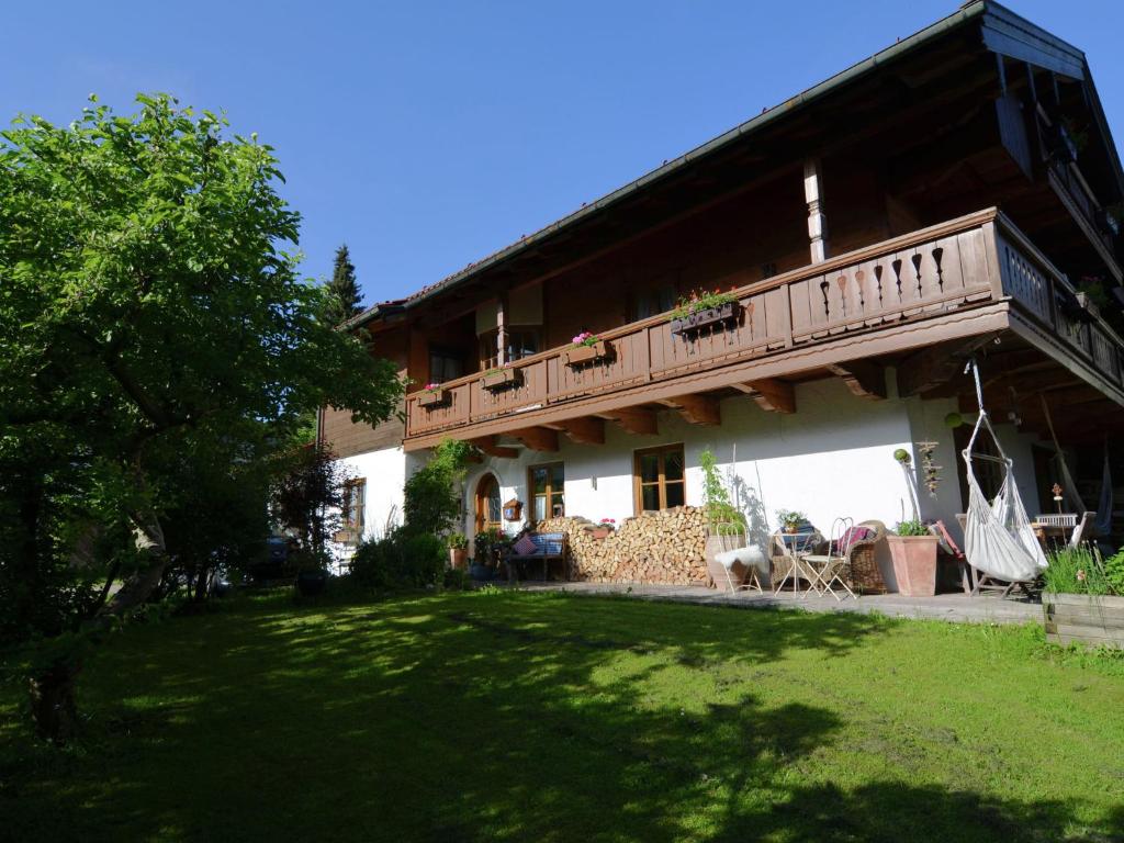 a house with a balcony and a yard at Apartment in Ruhpolding with Alps view in Ruhpolding