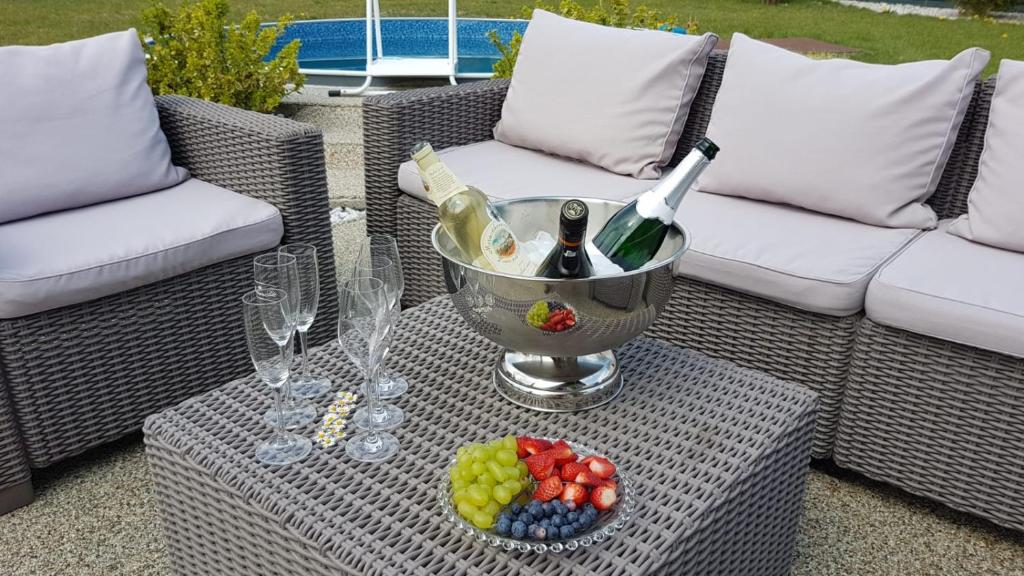 einen Tisch mit Weingläsern und eine Schale Obst in der Unterkunft apartmán Ela in Skalná
