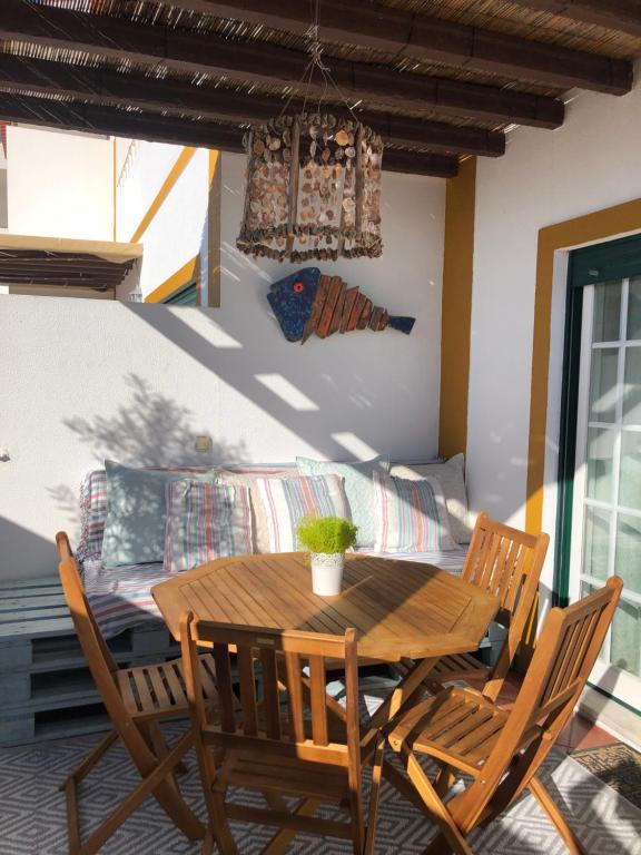una mesa de madera y sillas en una habitación con sofá en Trail House- Countryside and Beach, en Longueira