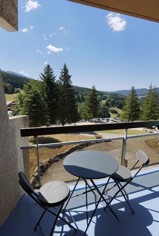 deux chaises et une table sur un balcon avec vue dans l'établissement Le balcon de villard, à Villard-de-Lans