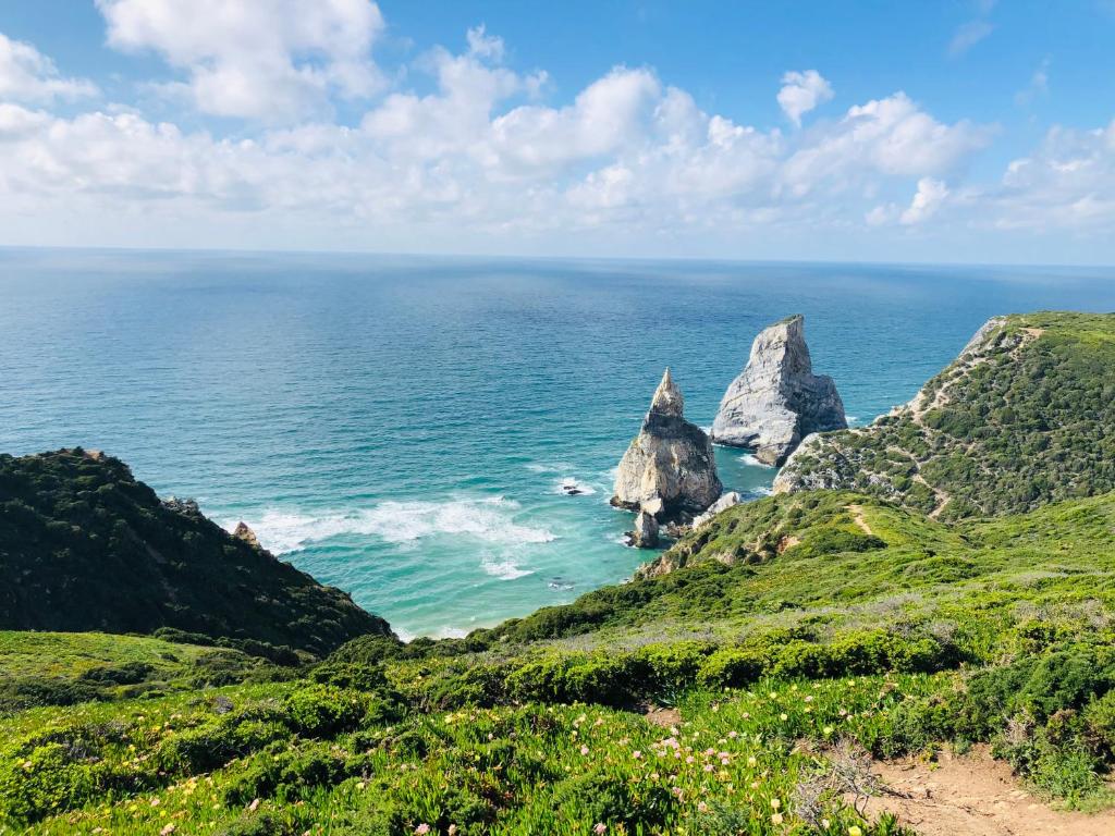 a view of two large rocks in the ocean at ribeira dos marinheiros amarelo in Sintra