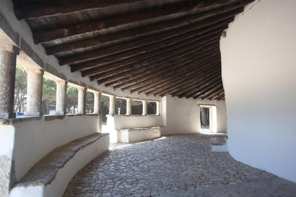 an empty building with a wooden roof and columns at ribeira dos marinheiros amarelo in Sintra