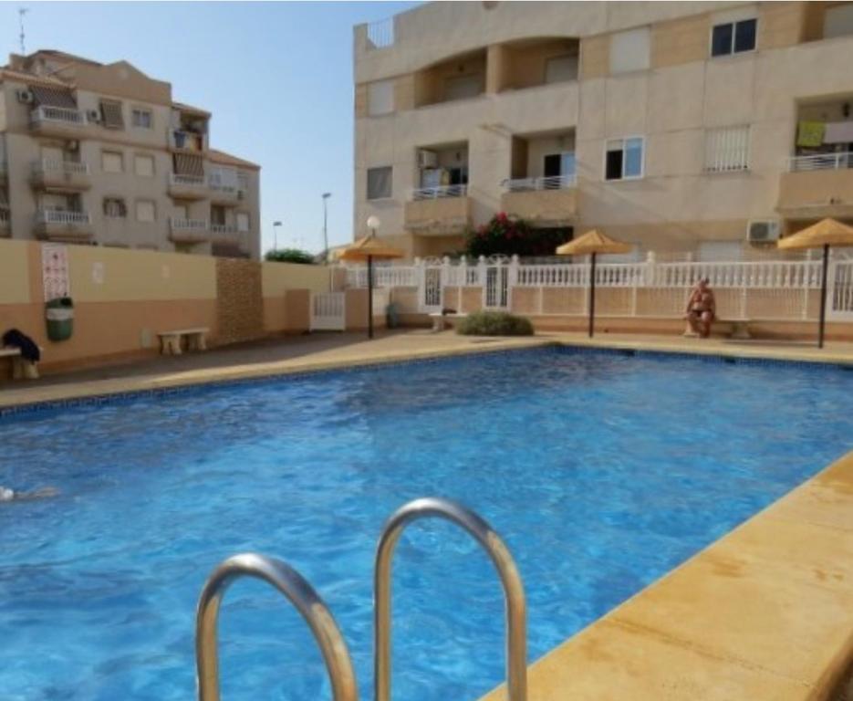 a swimming pool in front of a building at Bonito Apartamento de dos habitación y piscina in Torrevieja