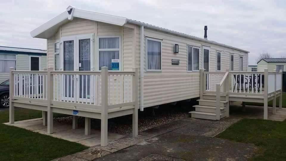 a tiny house with a porch and a staircase at Cosy caravans Sandhills 213 Butlins Skegness resort in Ingoldmells