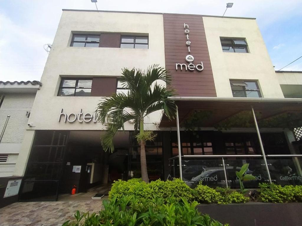 um hotel com uma palmeira em frente em Hotel Med 70 em Medellín