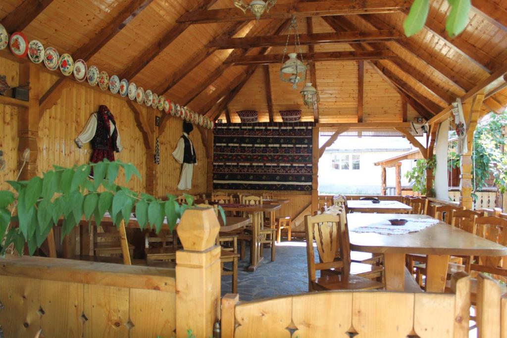 a restaurant with tables and chairs and a wine cellar at ILEANA Săpânța in Săpânța
