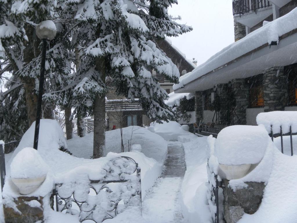 a yard covered in snow next to a house at Hotel Tripoli La Margherita in Limone Piemonte