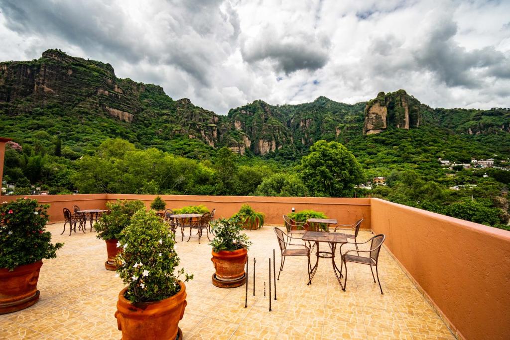 a balcony with tables and chairs with mountains in the background at La Pirámide del Tepozteco in Tepoztlán