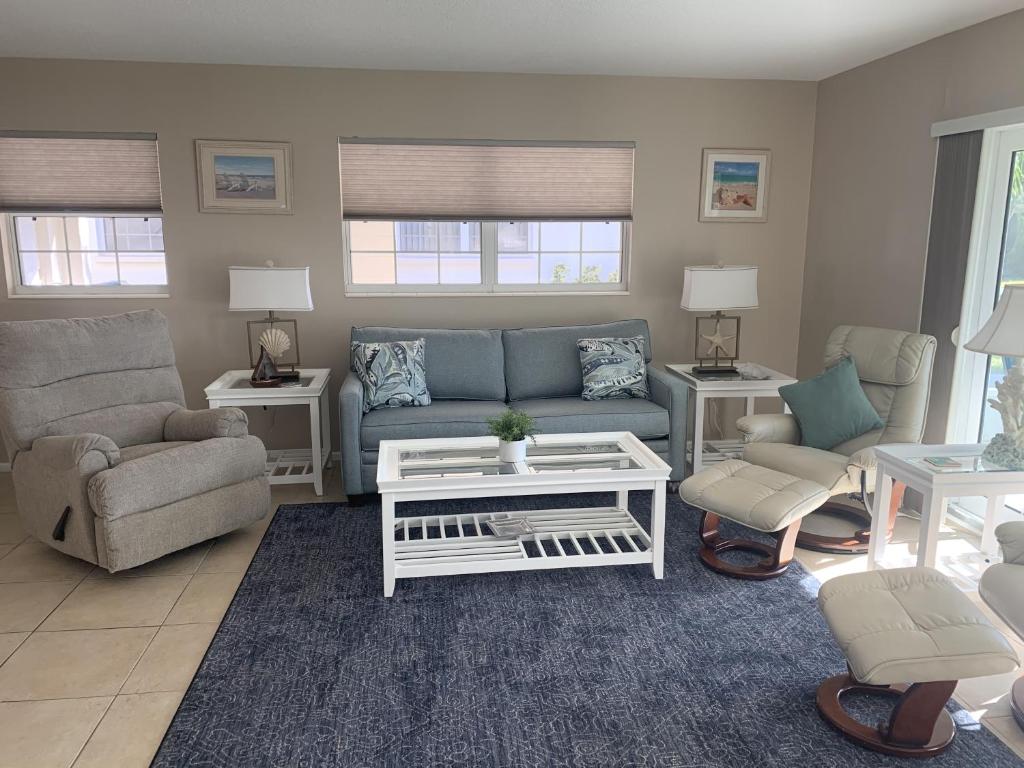 a living room with a blue couch and chairs at Island House Beach Resort 26 in Point O'Rocks