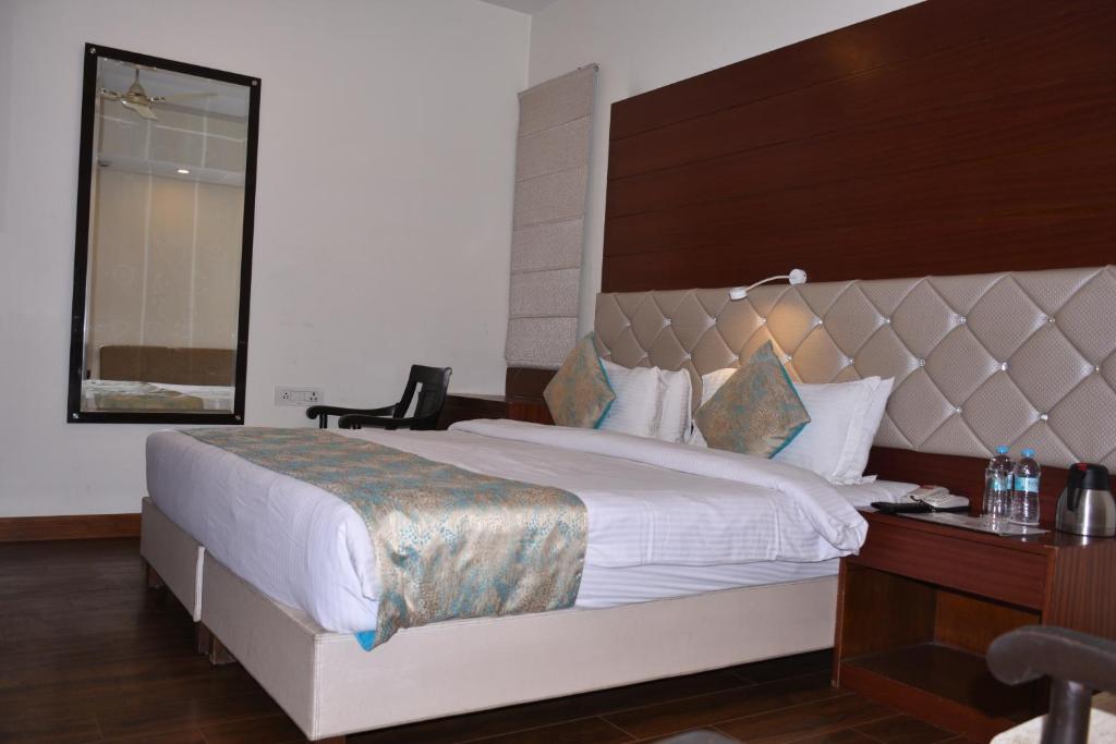a bedroom with a large bed and a desk and a window at Hotel Meadows in Varanasi