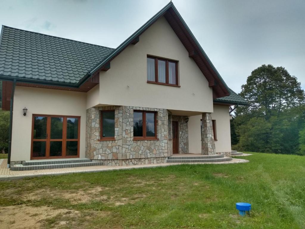 dom z zielonym trawnikiem przed nim w obiekcie BIESCZADNIK w Polańczyku