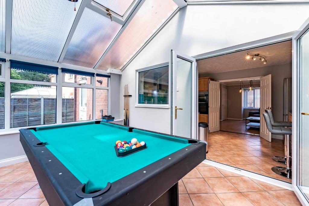 una mesa de billar en una habitación con ventanas en Chandlers House, en Peterborough