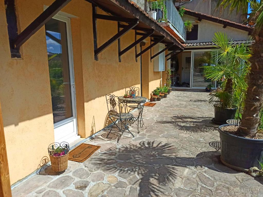 un patio con mesa y sillas junto a un edificio en Villa Raphaël, en Cransac