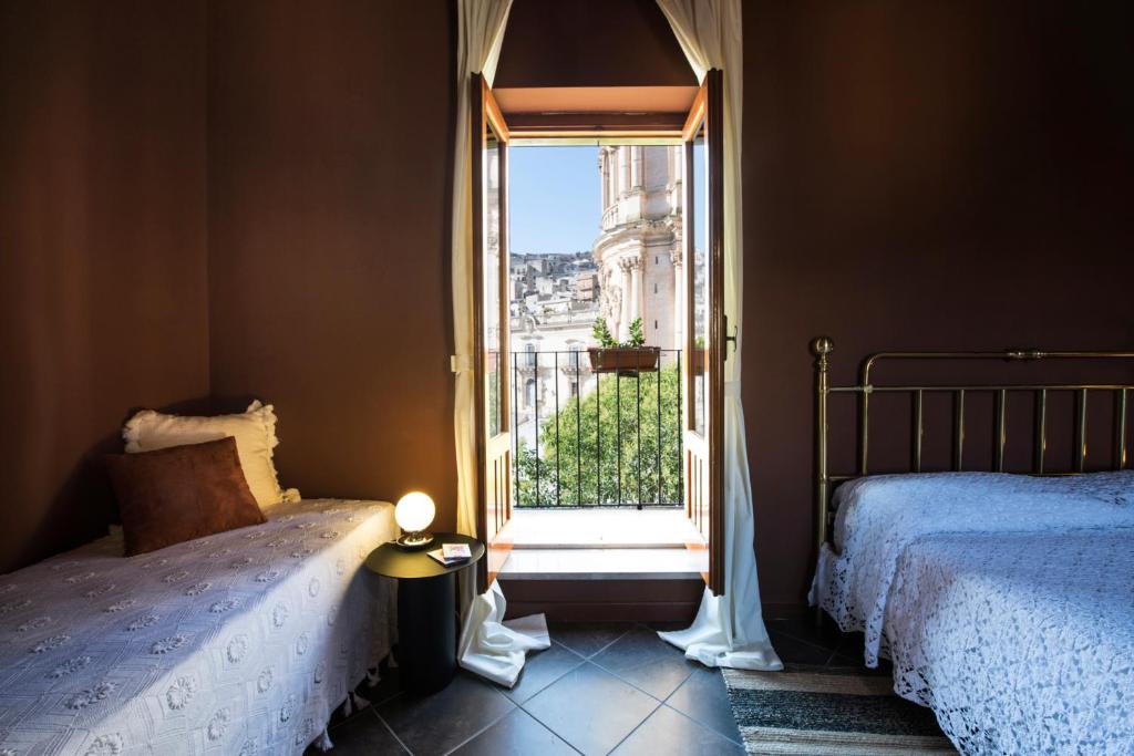 a bedroom with a bed and a window with a view at Le Stanze del Cioccolato in Modica