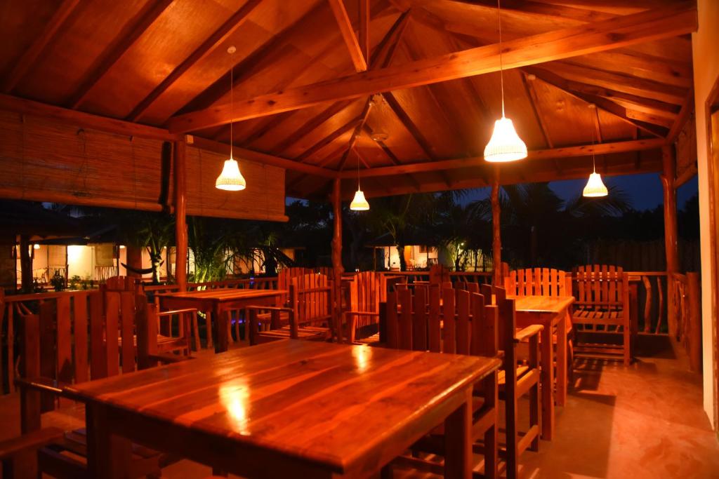 Prime Surfers Bungalow في آروغام باي: مطعم بطاولات خشبية وكراسي واضاءات