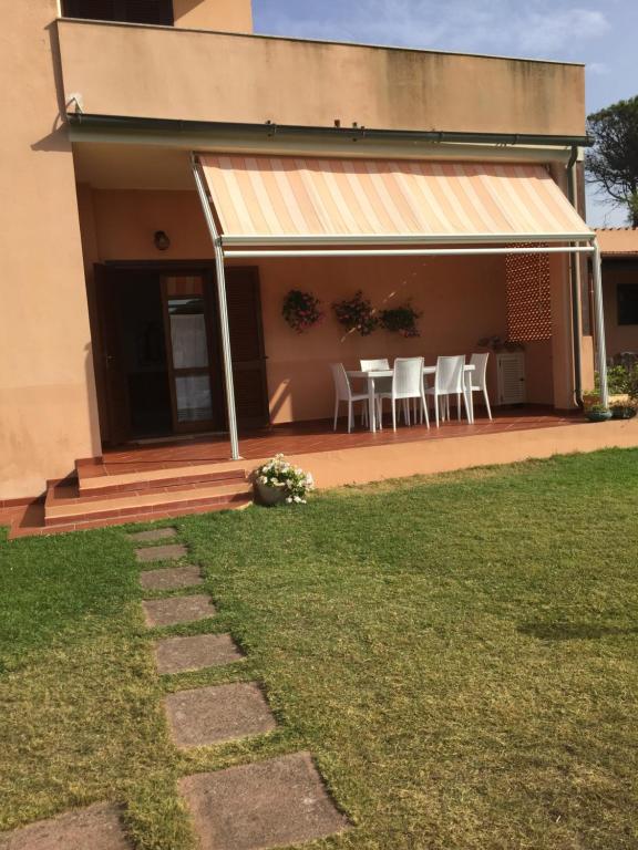 una casa con portico con sedie e tavolo di La casa sotto la torre a Chia