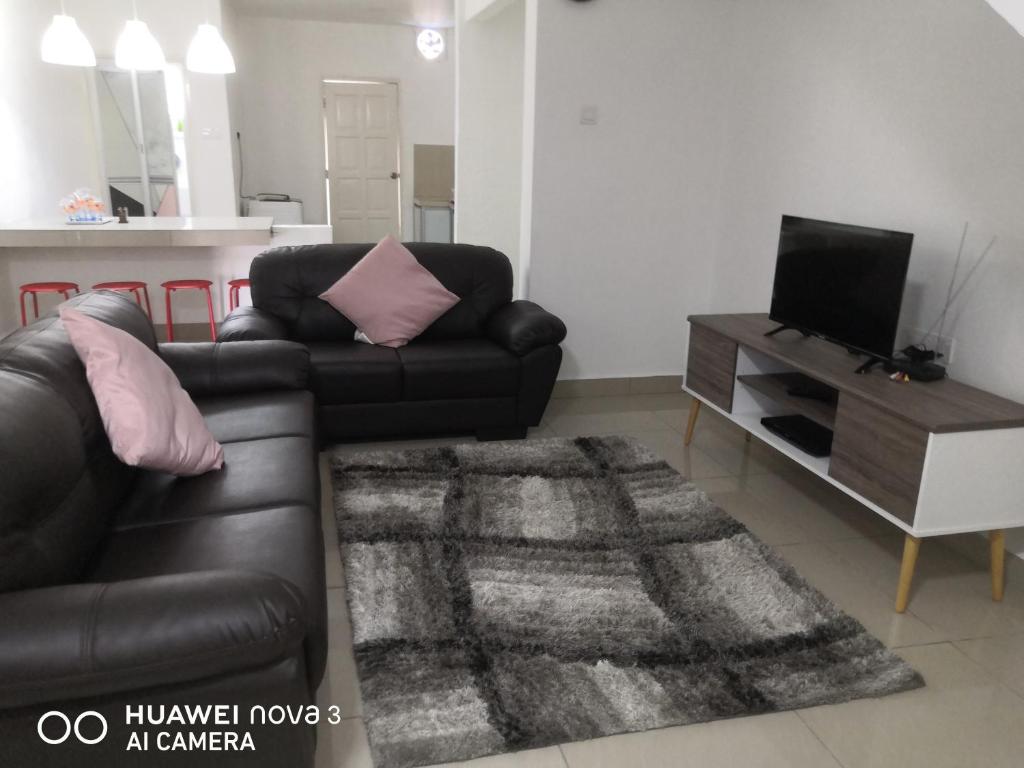 sala de estar con sofá de cuero y mesa en Abah 2 Room Homestay, en Pasir Gudang