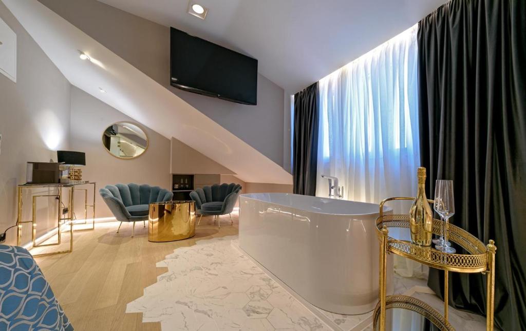 a living room with a large window and a tub at Lumiere Luxury Rooms in Split