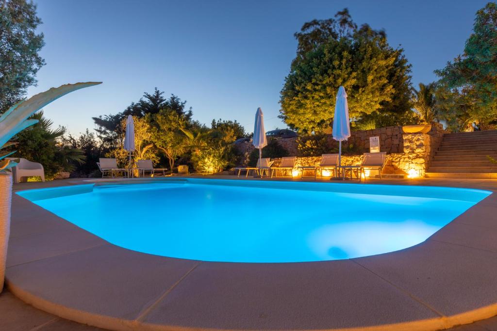 uma grande piscina com água azul à noite em Tenuta Aletheia B&B em Alliste
