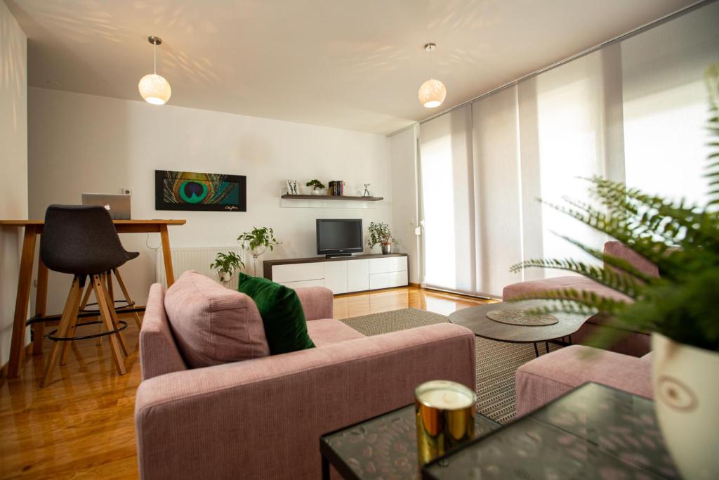 ein Wohnzimmer mit Sofa und Fernseher in der Unterkunft Bright 2-Bed Apartment Free Parking & WiFi - Walk to Old Town in Ljubljana