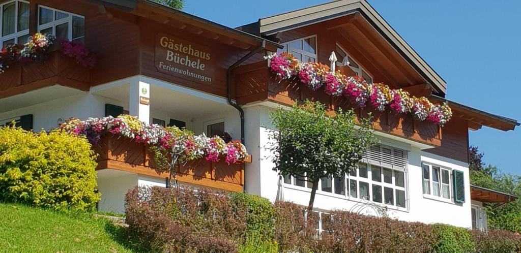 un edificio con cajas de flores en su lado en Gästehaus Büchele, en Hirschegg