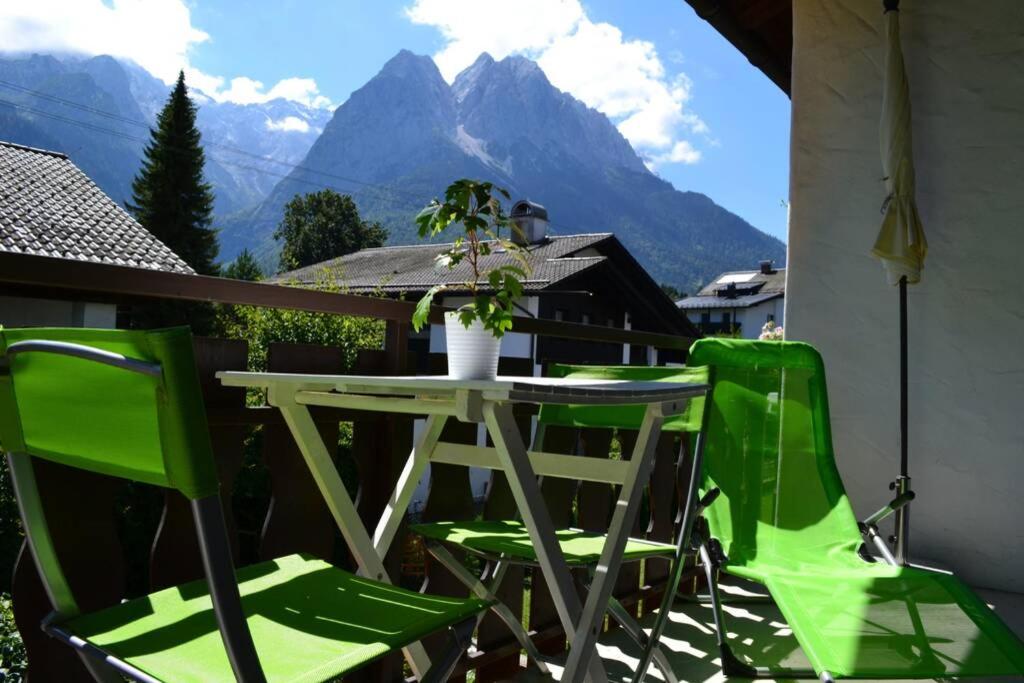uma mesa e cadeiras numa varanda com vista para as montanhas em Ferienwohnung Stimmer em Grainau