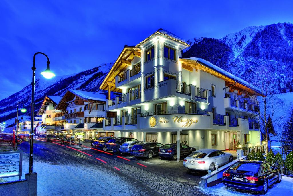 un hotel con coches estacionados en un estacionamiento en Hotel Garni Urezza en Ischgl