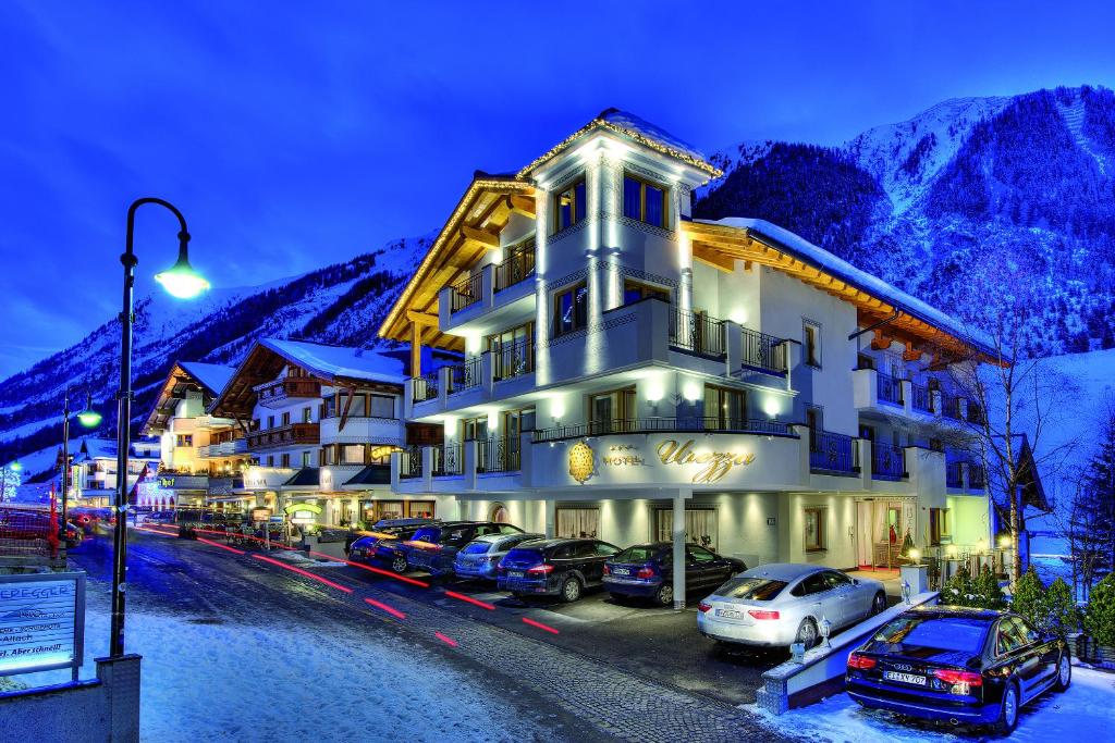a hotel with cars parked in a parking lot at Hotel Garni Urezza in Ischgl