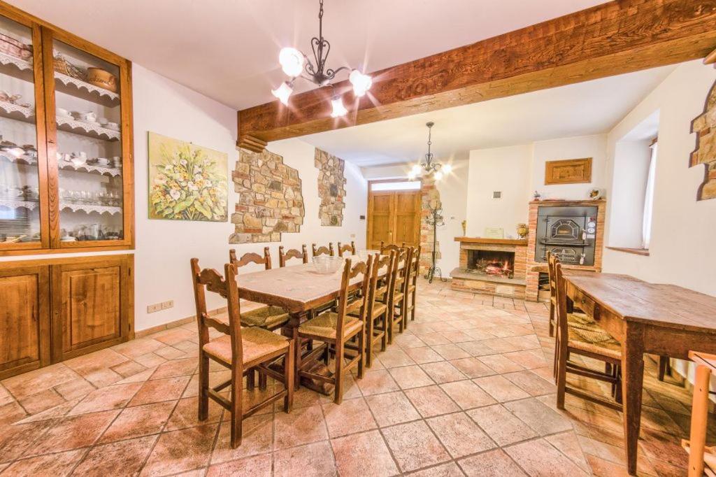 comedor con mesa, sillas y chimenea en Borgo Struginati, en Doglio