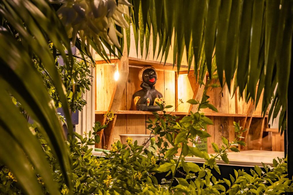 a statue sitting on a shelf in a room with plants at Hotel Fazenda Florença in Conservatória
