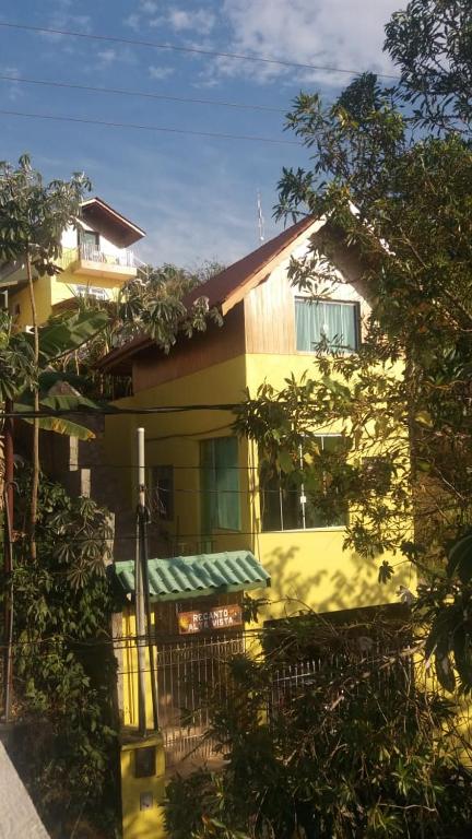 a yellow house with a green awning on it at Alta Vista in Penedo