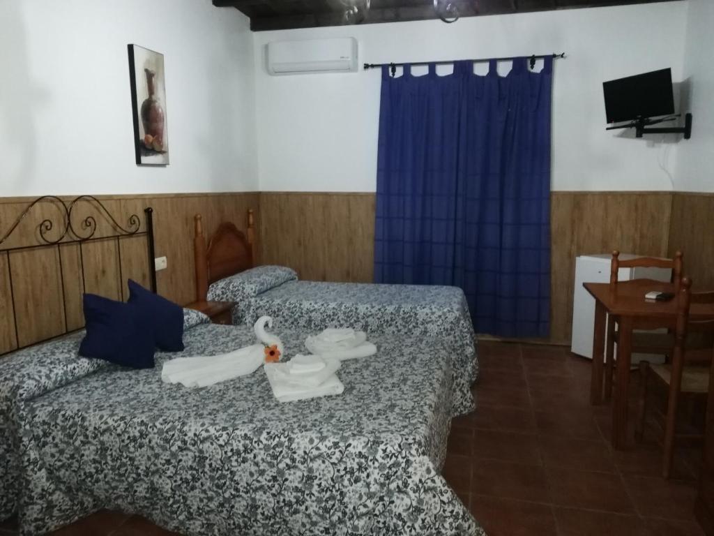 ein Hotelzimmer mit 2 Betten mit Schwänen darauf in der Unterkunft Hostal Breñaverde in Gaucín