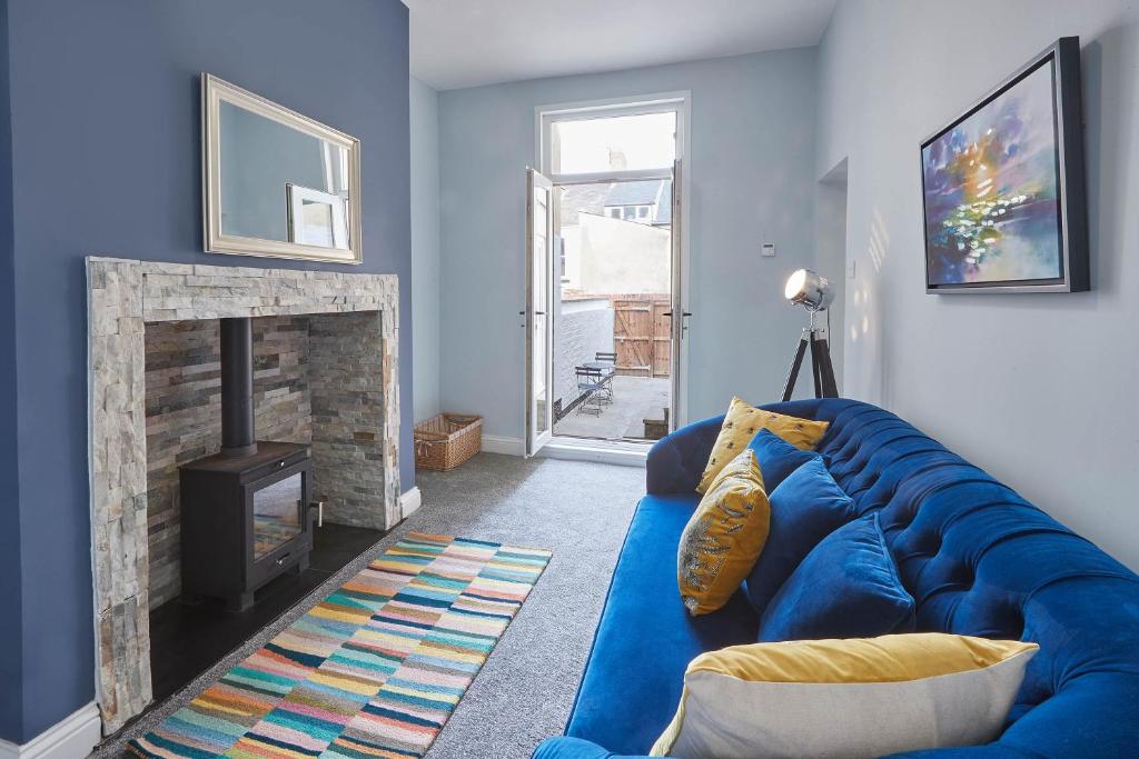 un sofá azul en una sala de estar con chimenea en Host & Stay - Riftswood at Ruby en Saltburn-by-the-Sea