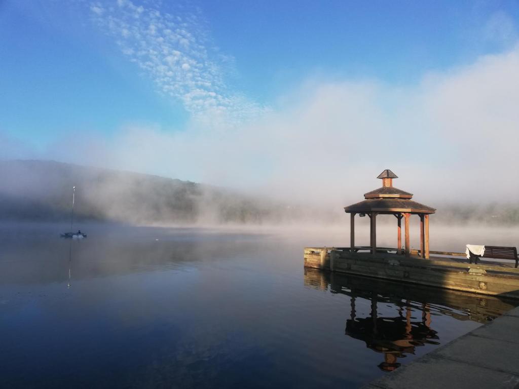 a misty lake with a wooden dock in the middle at Hotel Mont-Tremblant in Mont-Tremblant