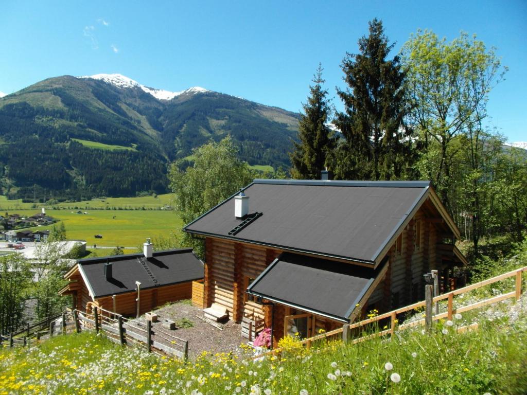 Lengalm Hütten I & II mit Sauna في Lengdorf: كابينة في حقل مع جبال في الخلفية