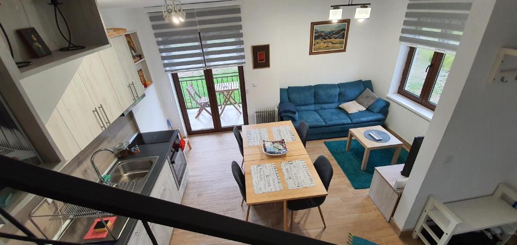 茲拉蒂博爾的住宿－VNB apartman Tornik-Zlatibor，客厅配有桌子和蓝色沙发