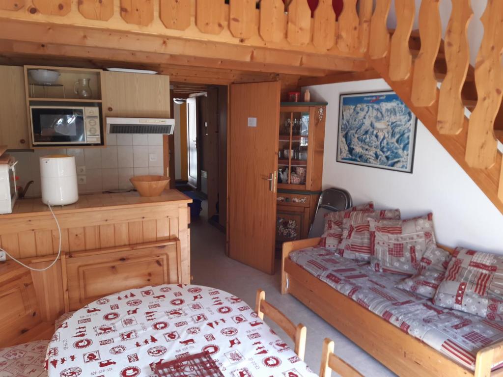 a kitchen and a living room with a bed and a table at Les Perthuis - Portes du Soleil in Châtel