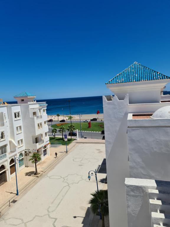 a view of the beach from the balcony of a building at Residence AL Massira CGI Fnideq plage in Fnidek